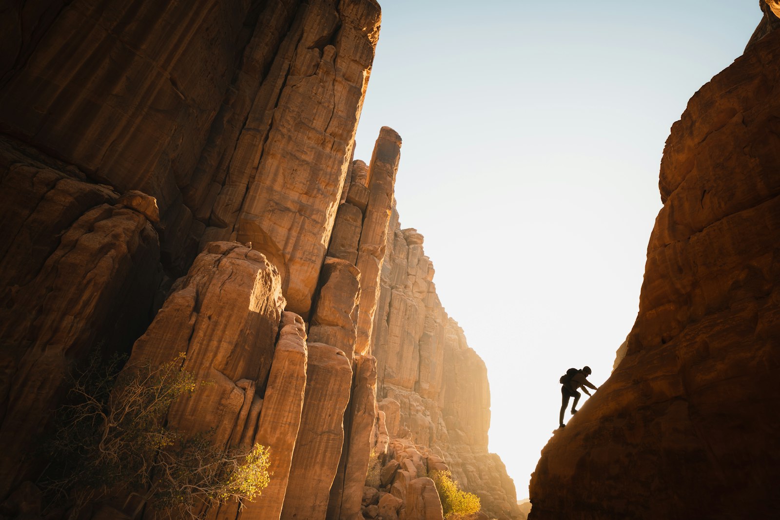 A rock climber silhouetted on red rock spires